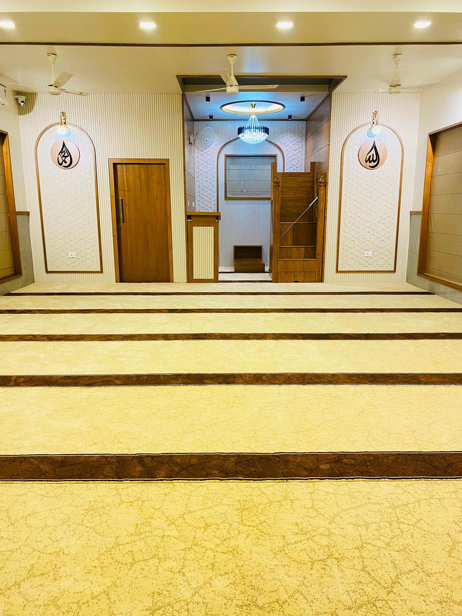 Wide-angle view of a fully carpeted masjid interior in Kerala